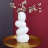 White ceramic pebble vase styled on coffee table with dried pampas grass