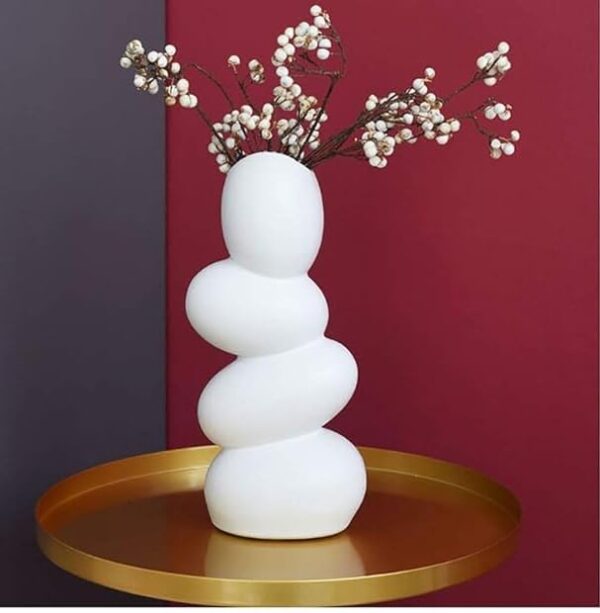 White ceramic pebble vase styled on coffee table with dried pampas grass