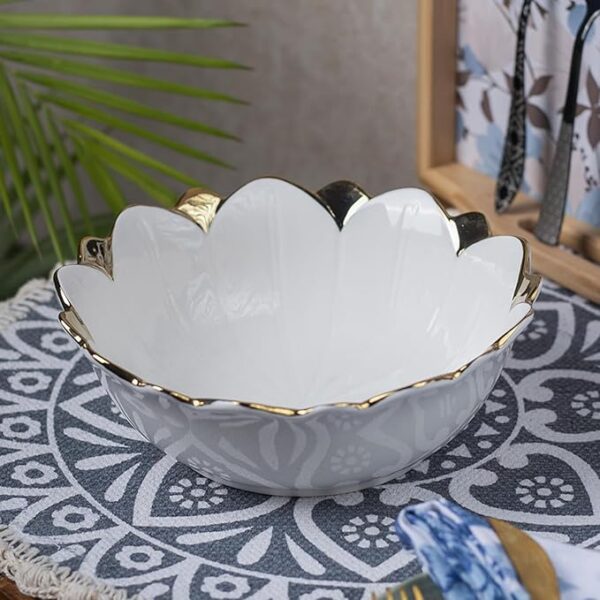 Antique off-white ceramic serving bowl placed on a wooden dining table.