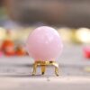 Natural pink rose quartz sphere with metal decorative stand