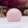 Polished rose quartz orb with stylish metal base