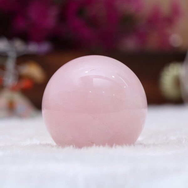 Polished rose quartz orb with stylish metal base