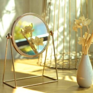 Golden round rotating vanity mirror with polished metal frame