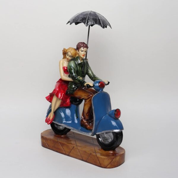 Romantic home décor showpiece of couple on a classic scooter