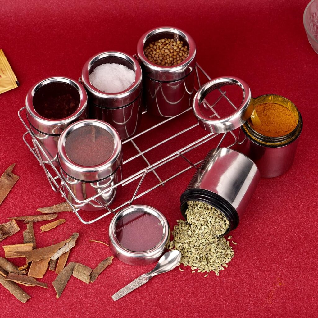 Stainless steel masala box with stand placed on a kitchen counter