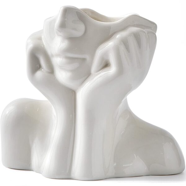 Small white ceramic vase with abstract face design for tabletop decoration