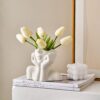 Small white ceramic face flower vase enhancing modern home aesthetics