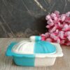 Elegant white ceramic butter dish with wooden lid on kitchen counter