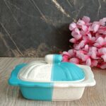 Elegant white ceramic butter dish with wooden lid on kitchen counter