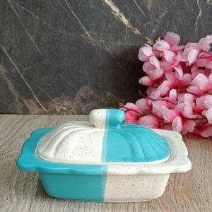 Elegant white ceramic butter dish with wooden lid on kitchen counter