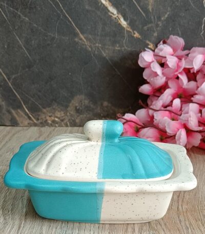 Elegant white ceramic butter dish with wooden lid on kitchen counter