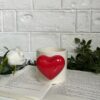 Cute red ceramic mug with heart-shaped handle and inner pop heart, perfect for gifting.