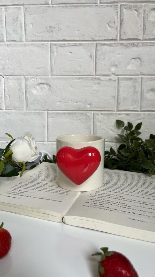 Cute red ceramic mug with heart-shaped handle and inner pop heart, perfect for gifting.