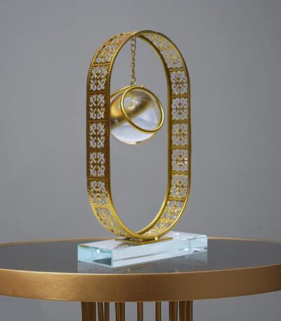 Clear crystal ball ornament displayed on a gold metal stand for elegant home décor