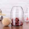 Elegant glass storage jar with wooden ball top for modern kitchens
