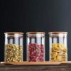 Transparent food storage jar with sealed wooden cover on white background