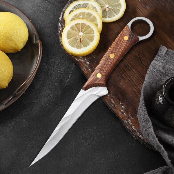 Professional chef boning knife cutting fresh meat on wooden board