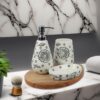 White ceramic soap dispenser, tray, and toothbrush holder arranged neatly on a bathroom counter