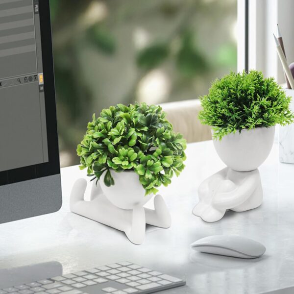 Decorative ceramic pots shaped like human figures with green fake succulents for modern home styling.