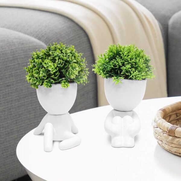 Set of four creative mini fake succulent plants in human design ceramic pots for desktop décor.