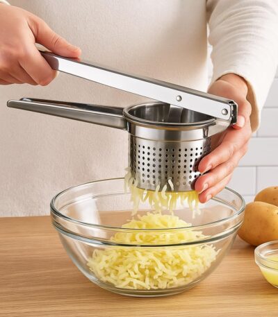 Manual stainless steel hand press juicer placed on a kitchen countertop