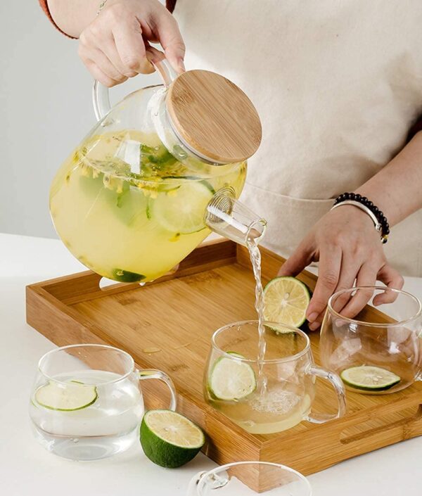 Glass jug with wooden lid filled with lemon water