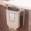 Compact wall-mounted trash can with collapsible design